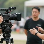 Équipe de tournage en action, caméra et lumières.